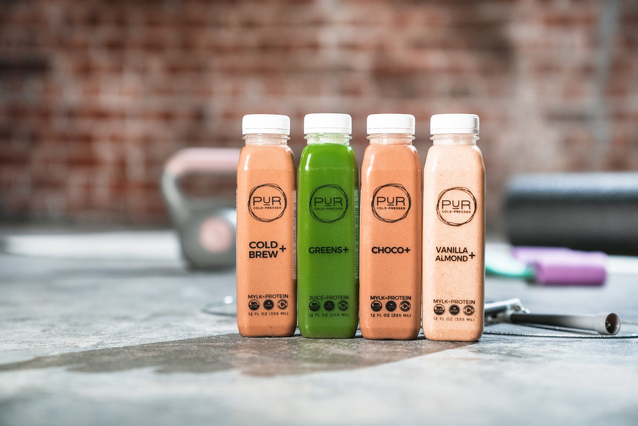 PUR protein juices and mylks with gym equipment