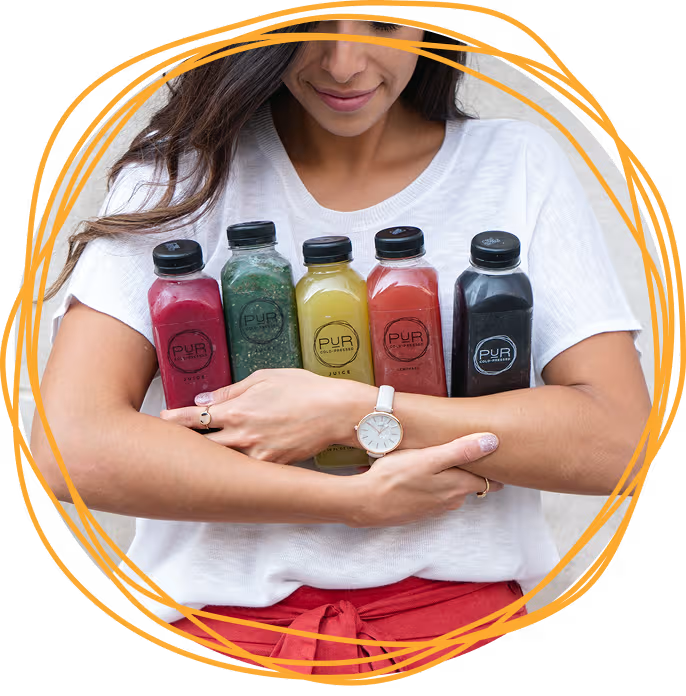 PUR community member holding cold-pressed juices